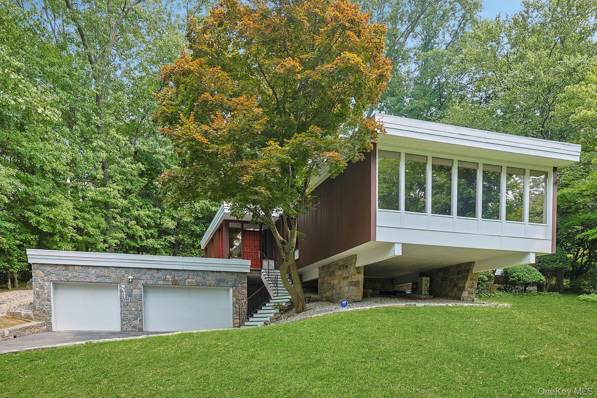 20 Sprain Valley Road Scarsdale, NY 10583 - Photo 2 of 30 Distinctive contemporary architecture is beautifully complemented by natural stone accents, expansive windows, and a private, park-like setting.