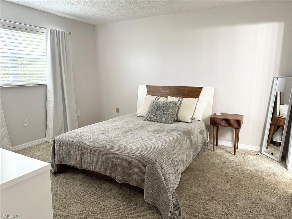 170 Turtle Lake Court, Unit 210 Naples, FL 34105 - Photo 4 of 20 a bedroom with a bed and a couch