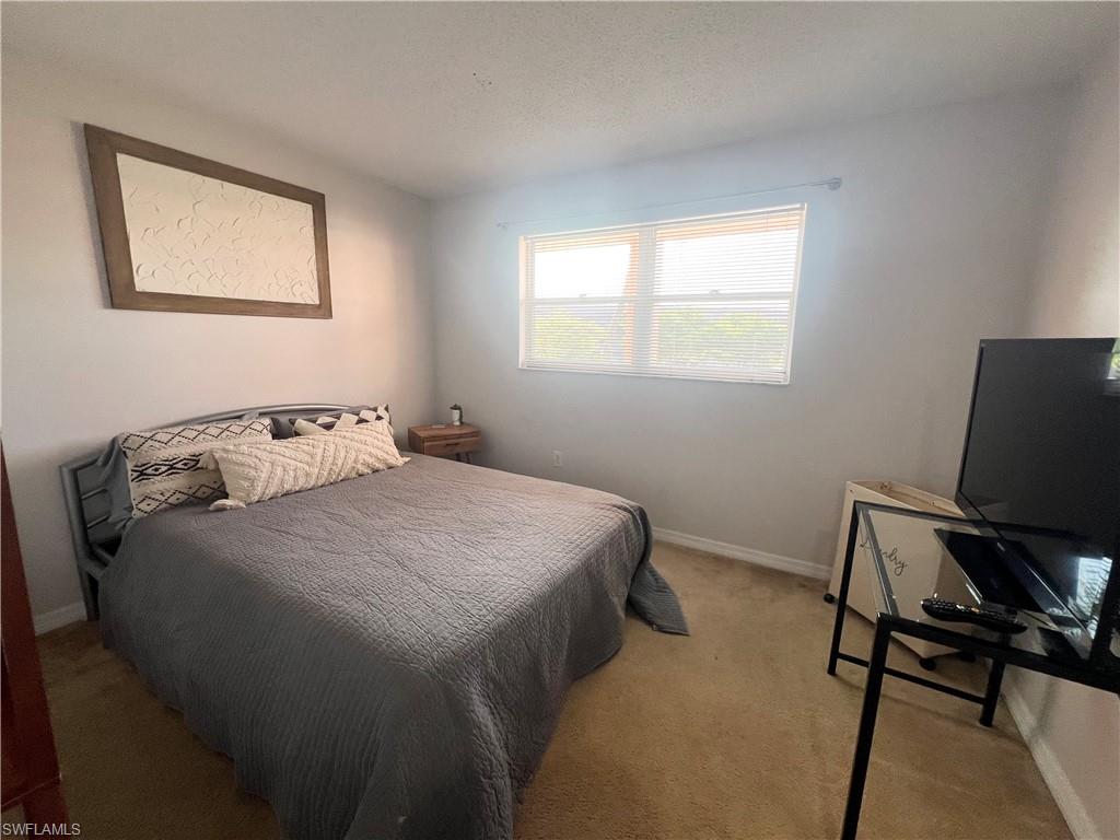 170 Turtle Lake Court, Unit 210 Naples, FL 34105 - Photo 7 of 20 a bedroom with a bed and chair