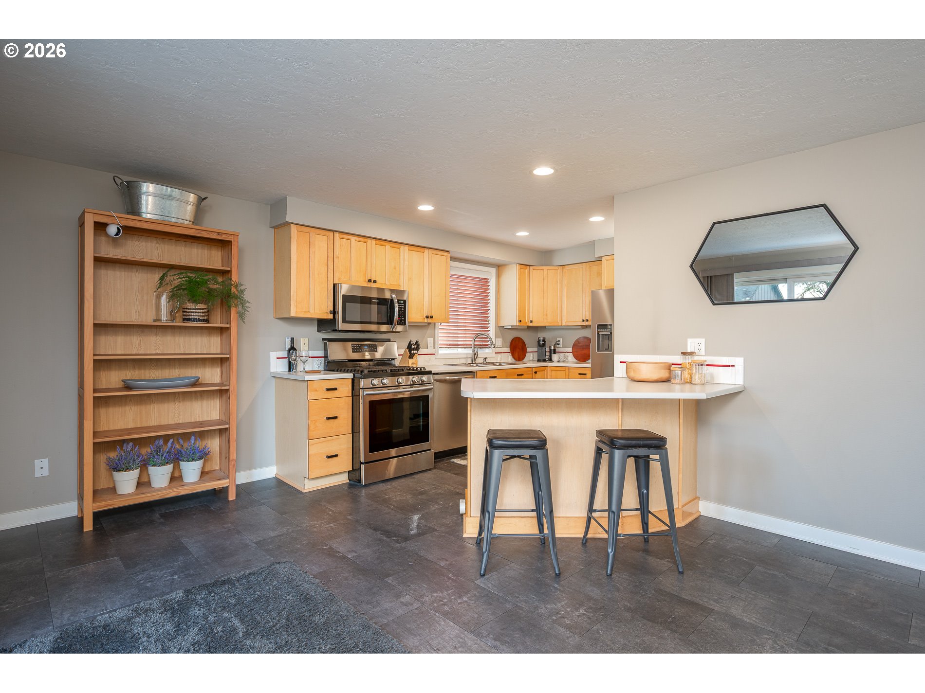 8670 Southwest Stratford Court Tigard, OR 97224 - Photo 19 of 42 a kitchen with stainless steel appliances a stove a sink a refrigerator white cabinets and wooden floor