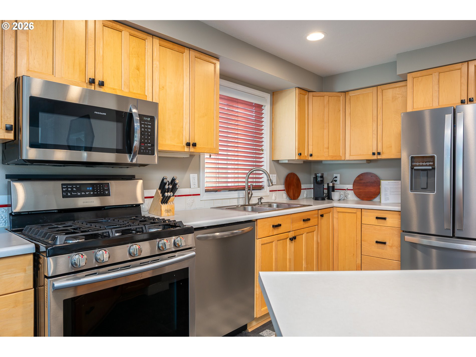 8670 Southwest Stratford Court Tigard, OR 97224 - Photo 22 of 42 a kitchen with stainless steel appliances granite countertop a stove a sink and a microwave