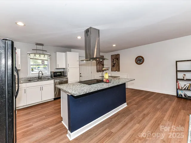 a kitchen with stainless steel appliances granite countertop a sink stove and wooden floor