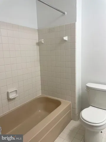 a white bath tub sitting next to a toilet