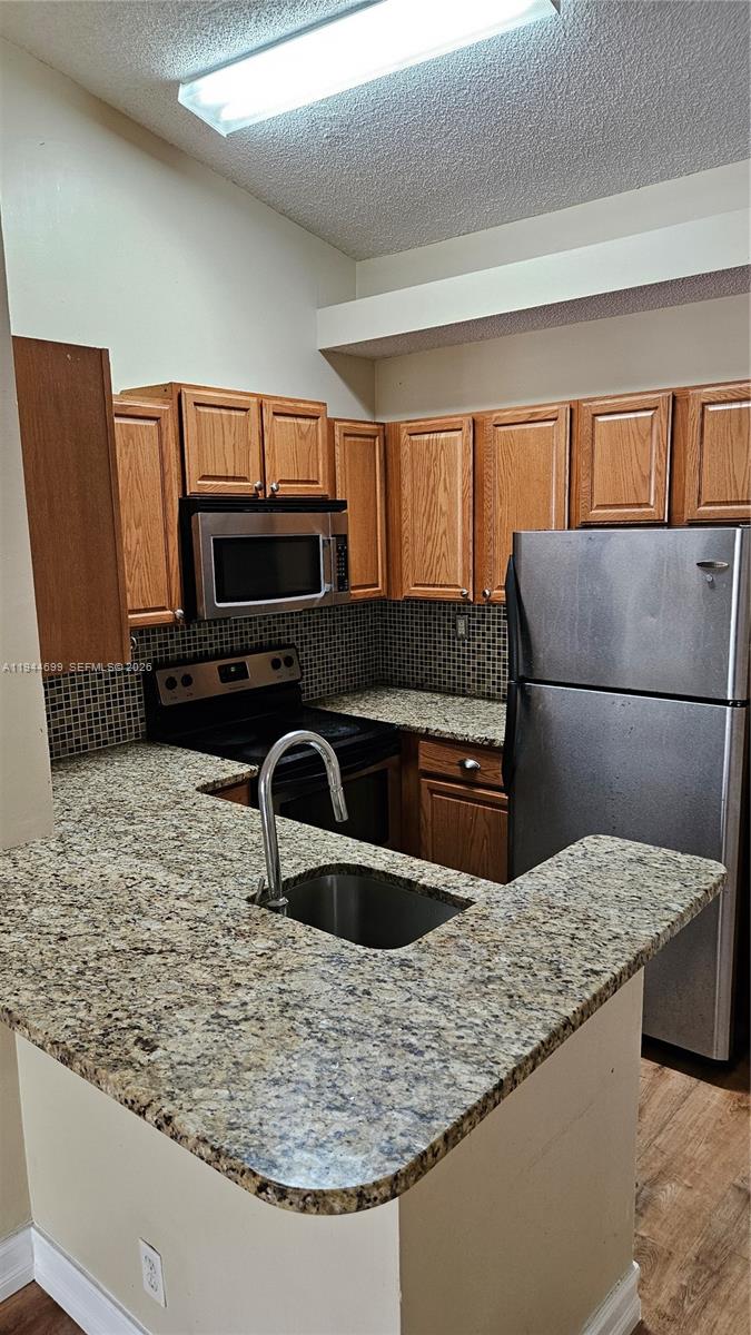 801 Lyons Road, Unit 19203 Coconut Creek, FL 33063 - Photo 11 of 28 a kitchen with kitchen island granite countertop a sink and a stove