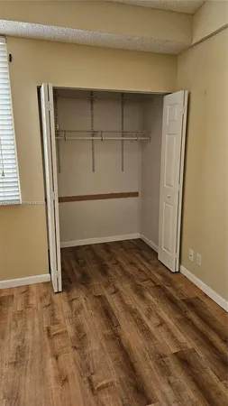 a view of a room with wooden floor and bench