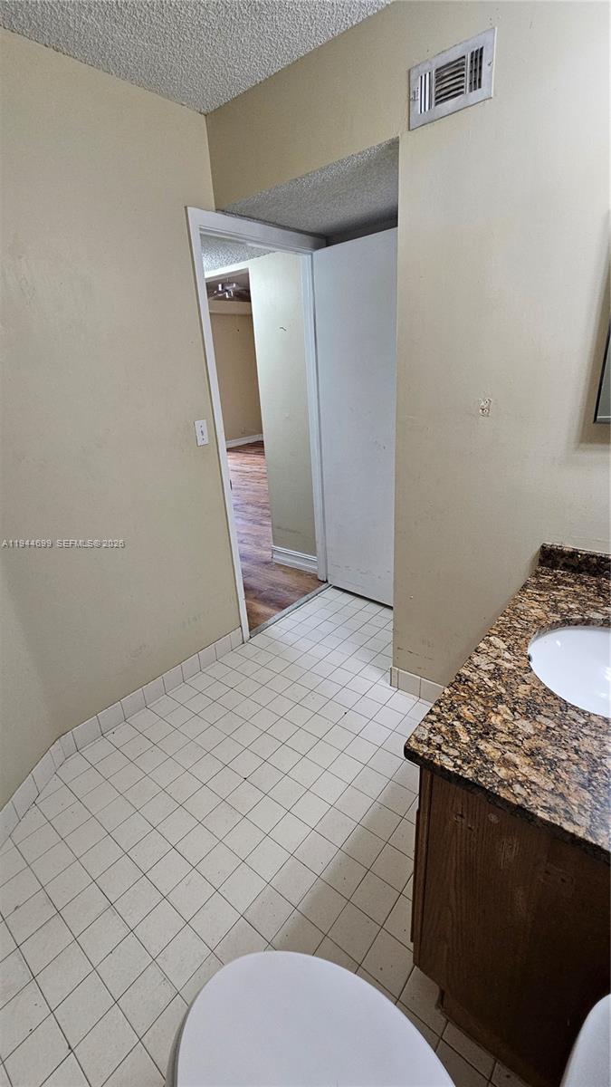 801 Lyons Road, Unit 19203 Coconut Creek, FL 33063 - Photo 25 of 28 a bathroom with a sink a toilet and mirror
