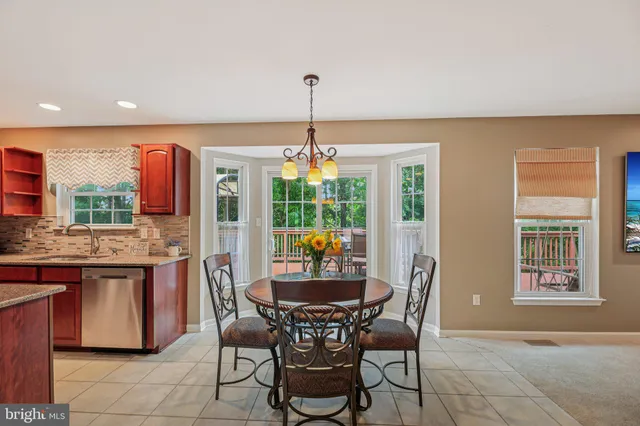 a dining room with granite countertop furniture a chandelier and kitchen view