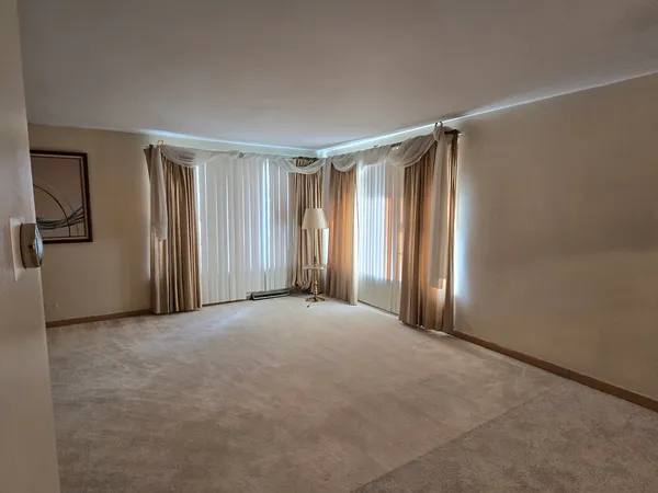 an empty room with windows and closet area