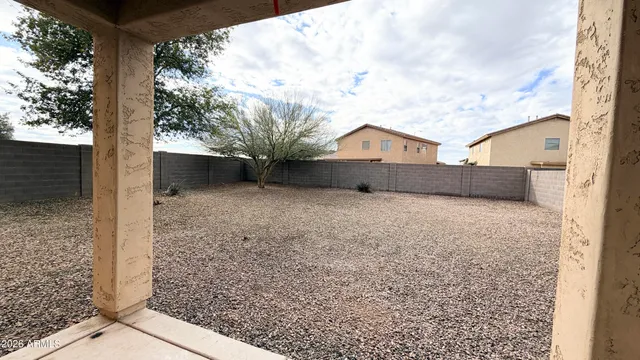 a view of a house with a large tree and wooden fence