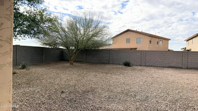 a view of backyard with wooden fence and large trees