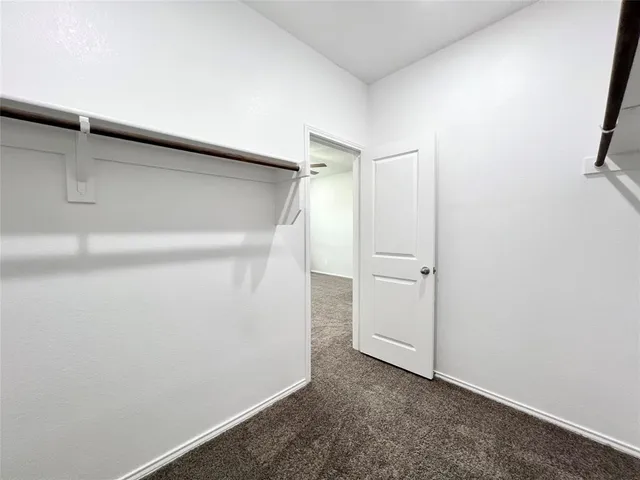 an empty room with a ceiling fan and window
