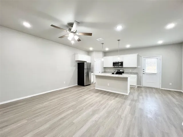a view of kitchen with granite countertop cabinets and refrigerator