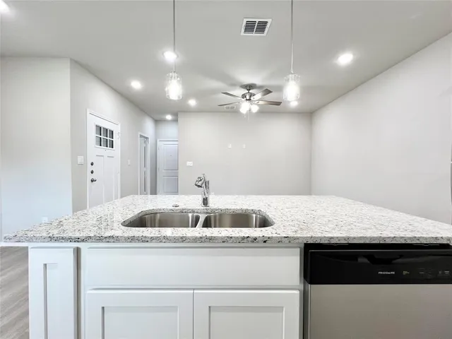 a kitchen with kitchen island granite countertop a sink and chandelier
