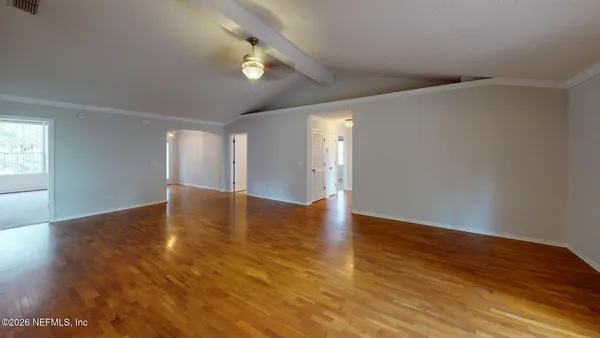 a view of empty room with wooden floor