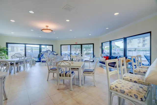 a outdoor space with lots of tables a large window and chairs