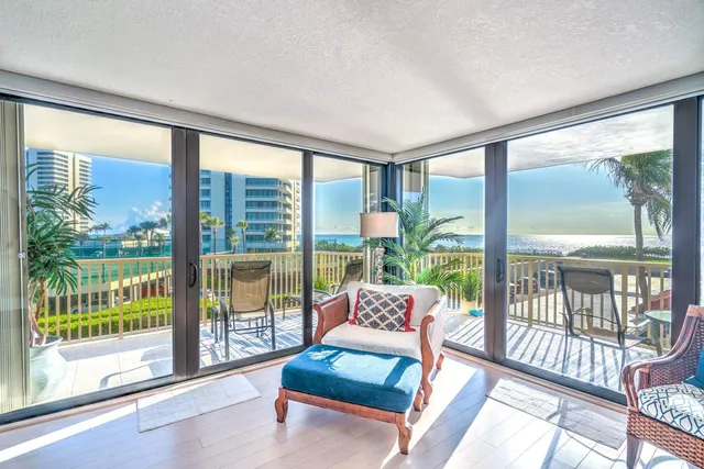 a living room with furniture and a floor to ceiling window