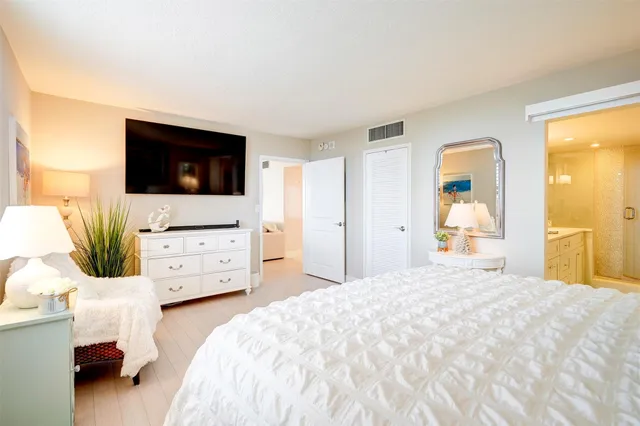 a bedroom with a bed and flat screen tv