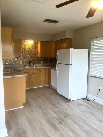 a kitchen with kitchen island a sink a stove a refrigerator and white cabinets