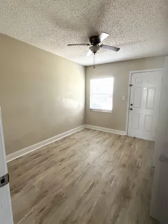 en empty room with window and ceiling fan