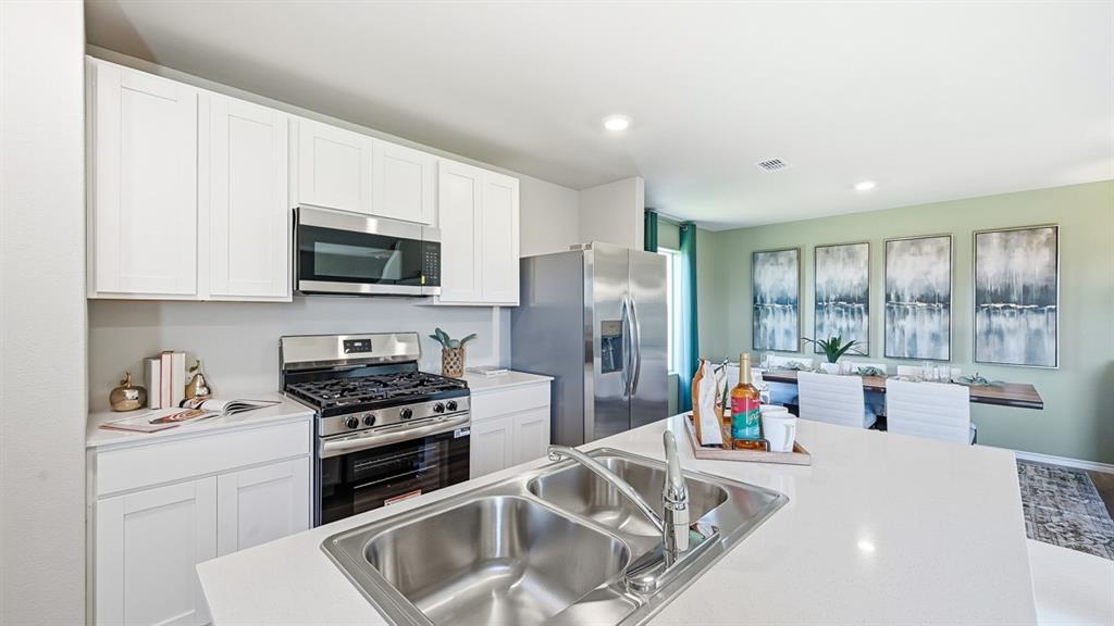 5512 Corduroy Road Krum, TX 76249 - Photo 1 of 38 a kitchen that has a lot of cabinets a sink and appliances