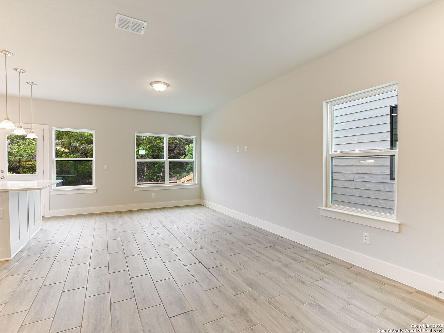 16011 Babcock Road, Unit 22 San Antonio, TX 78255 - Photo 4 of 20 a view of an empty room with a window and wooden floor