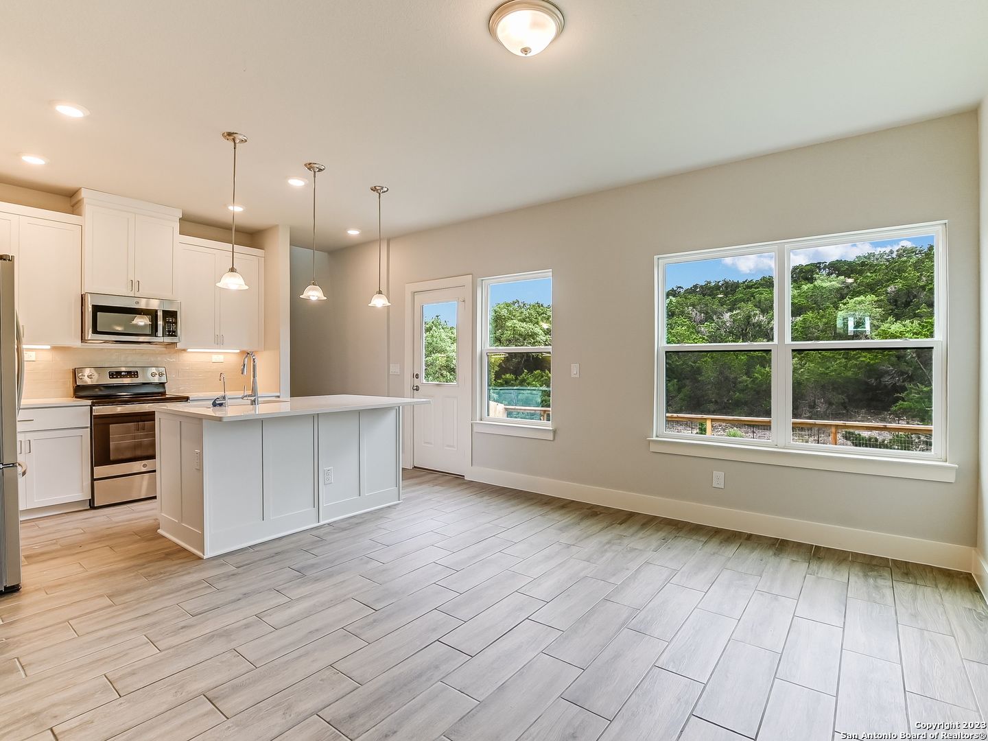 16011 Babcock Road, Unit 22 San Antonio, TX 78255 - Photo 5 of 20 a large kitchen with stainless steel appliances kitchen island granite countertop a large stove a sink and a microwave
