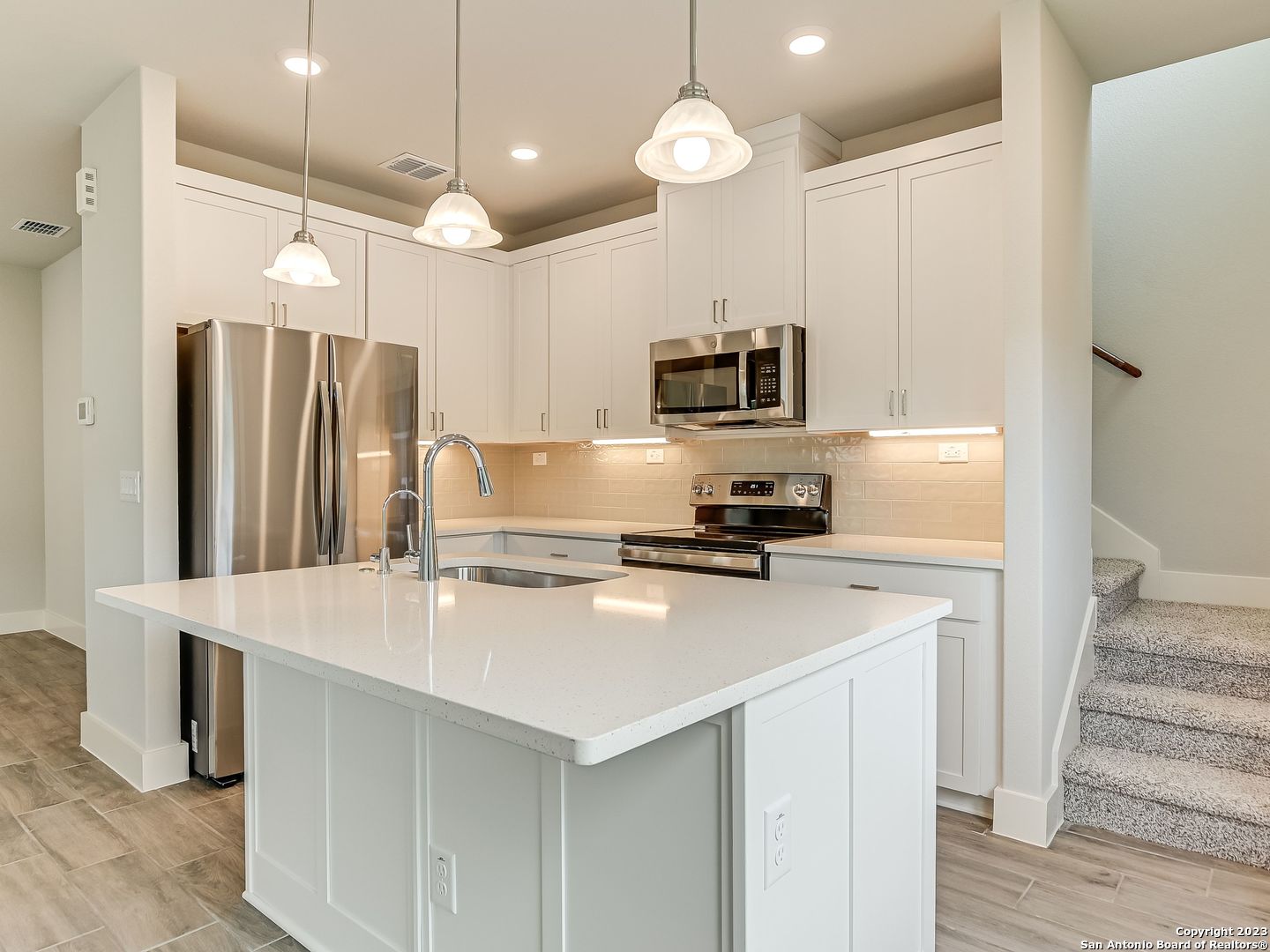 16011 Babcock Road, Unit 22 San Antonio, TX 78255 - Photo 7 of 20 a kitchen with kitchen island white cabinets and stainless steel appliances