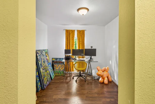 a view of a workspace with furniture and a wooden floor