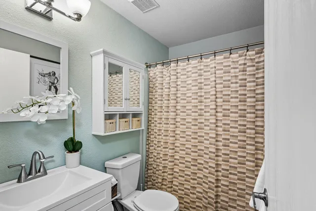 a bedroom with a bed a window and a ceiling fan