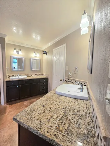 a bathroom with a granite countertop sink and a mirror