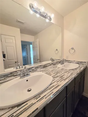 a bathroom with a granite countertop sink and a mirror