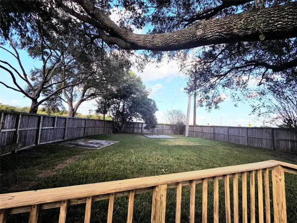 a view of a yard with wooden fence