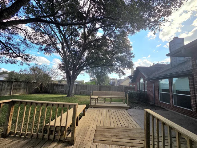 a view of backyard with deck and trees
