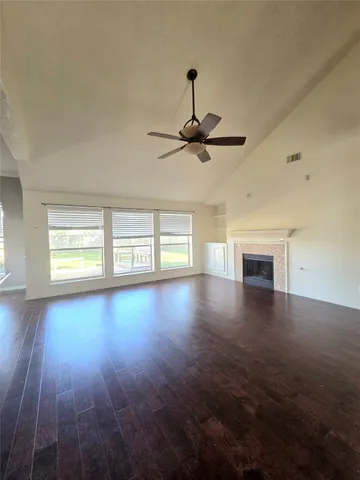 a view of empty room with wooden floor and window