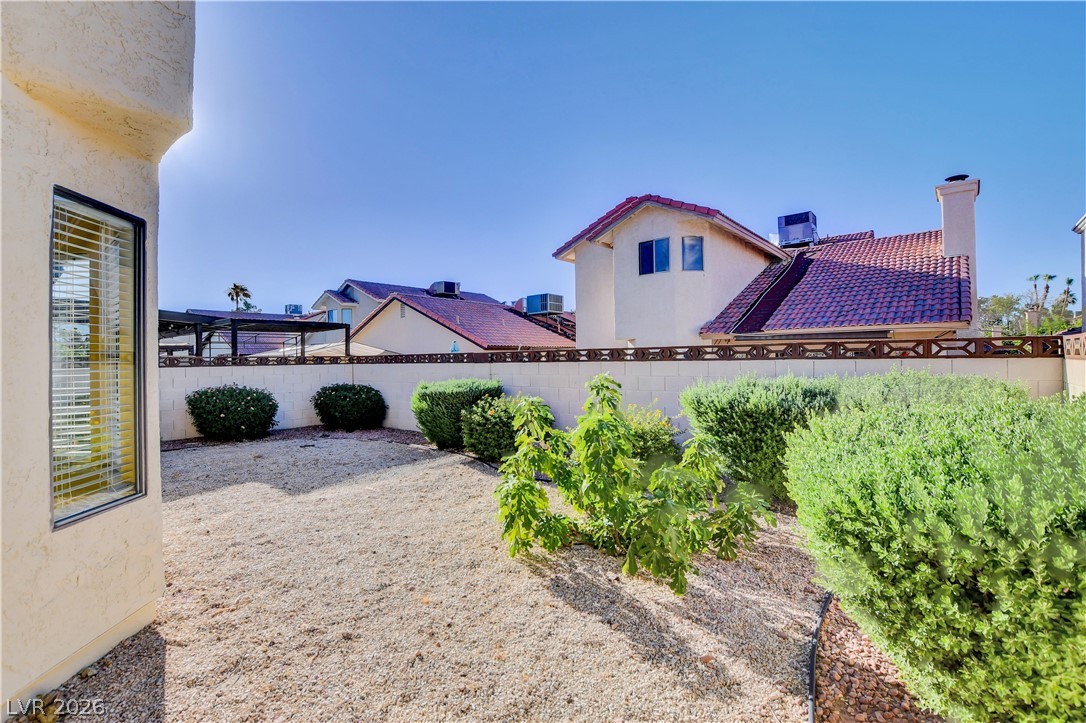 6440 Hartwood Road Las Vegas, NV 89108 - Photo 56 of 59 A private backyard oasis awaits, featuring a low-maintenance gravel landscape and lush perimeter hedges.