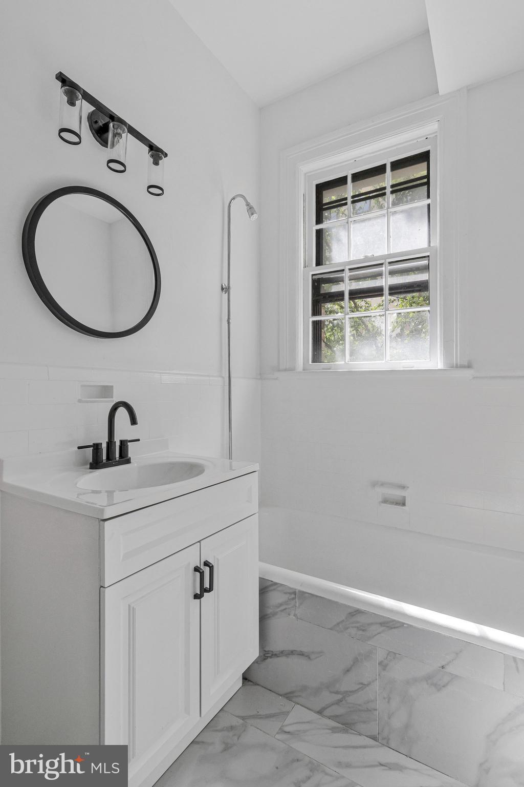 2707 Adams Mill Road Northwest, Unit 205 Washington, DC 20009 - Photo 20 of 28 a bathroom with a sink a toilet and a mirror