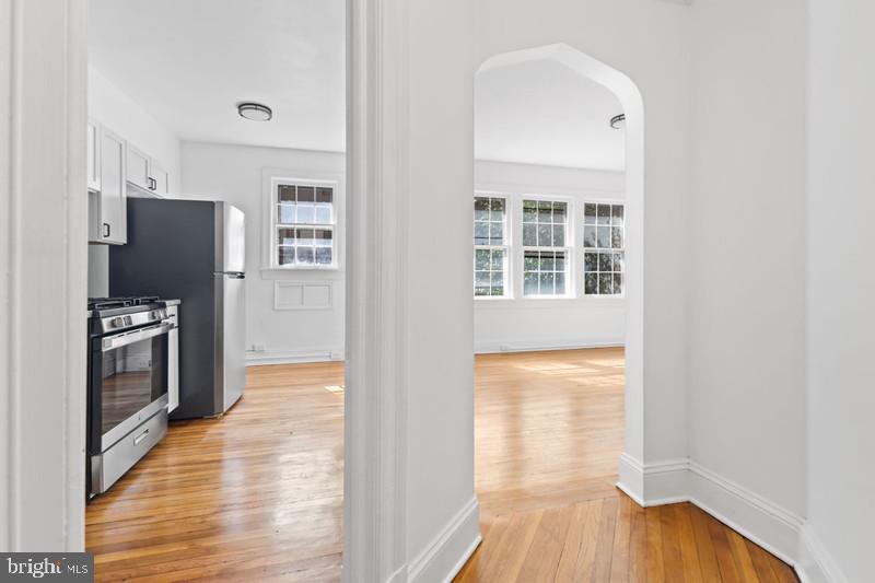 2707 Adams Mill Road Northwest, Unit 205 Washington, DC 20009 - Photo 2 of 28 a view of a kitchen with wooden floor and a refrigerator