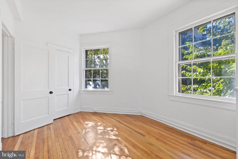 2707 Adams Mill Road Northwest, Unit 205 Washington, DC 20009 - Photo 23 of 28 a view of empty room with wooden floor and fan