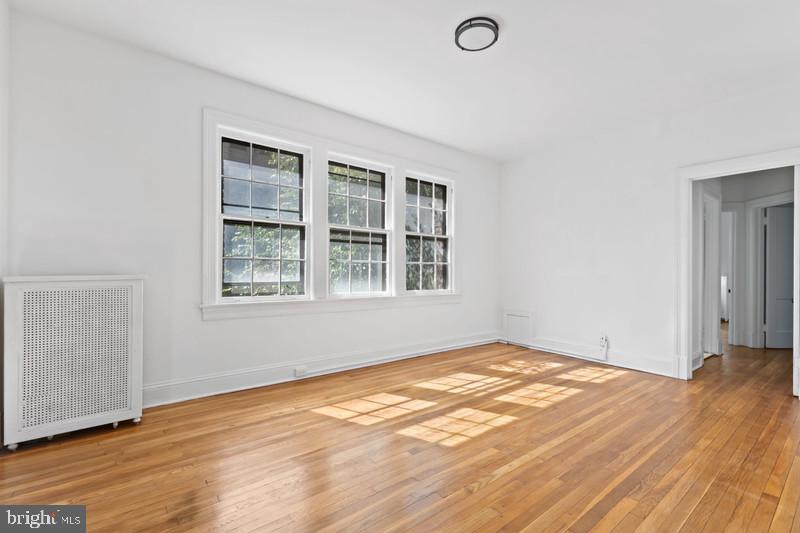 2707 Adams Mill Road Northwest, Unit 205 Washington, DC 20009 - Photo 4 of 28 a view of empty room with wooden floor and fan