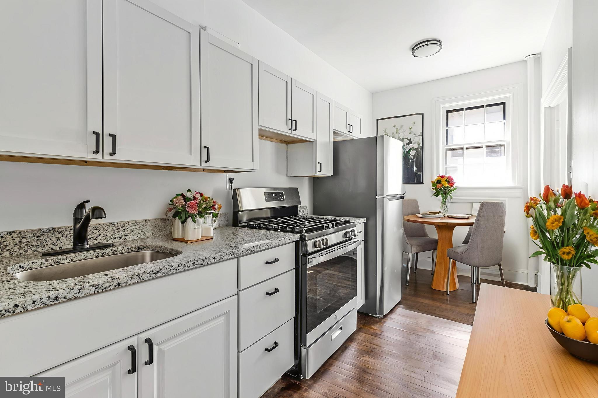 2707 Adams Mill Road Northwest, Unit 205 Washington, DC 20009 - Photo 10 of 28 a kitchen with granite countertop a sink stainless steel appliances and white cabinets