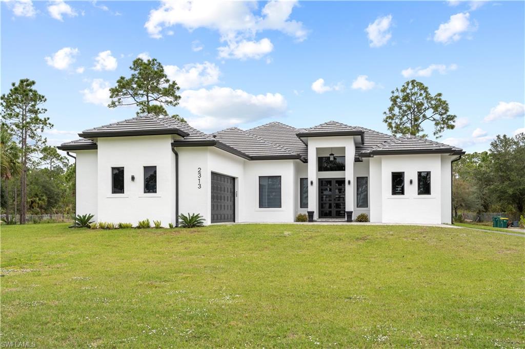2313 6th Avenue Southeast Naples, FL 34117 - Photo 1 of 36 a big white house with a big yard and large trees