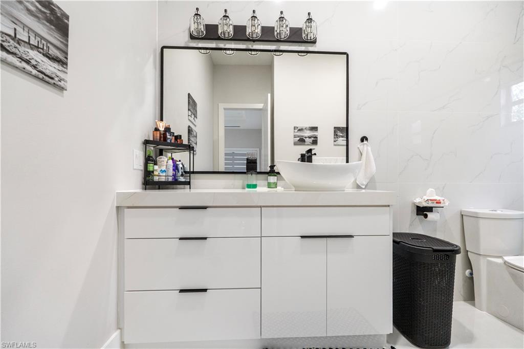2313 6th Avenue Southeast Naples, FL 34117 - Photo 17 of 36 a bathroom with a sink and a mirror