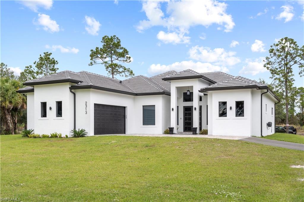 2313 6th Avenue Southeast Naples, FL 34117 - Photo 2 of 36 a front view of a house with a garden