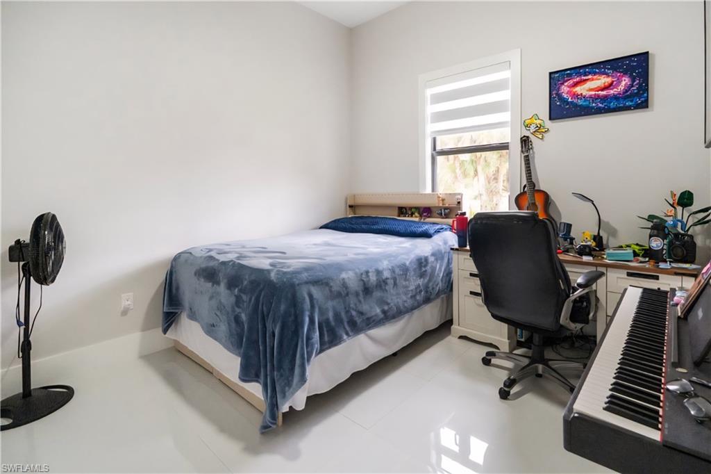 2313 6th Avenue Southeast Naples, FL 34117 - Photo 26 of 36 a bedroom with a bed and a chair