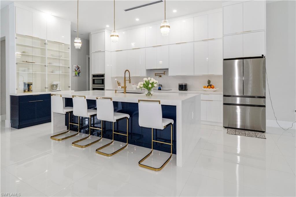 2313 6th Avenue Southeast Naples, FL 34117 - Photo 6 of 36 a kitchen with kitchen island a white counter top space and stainless steel appliances