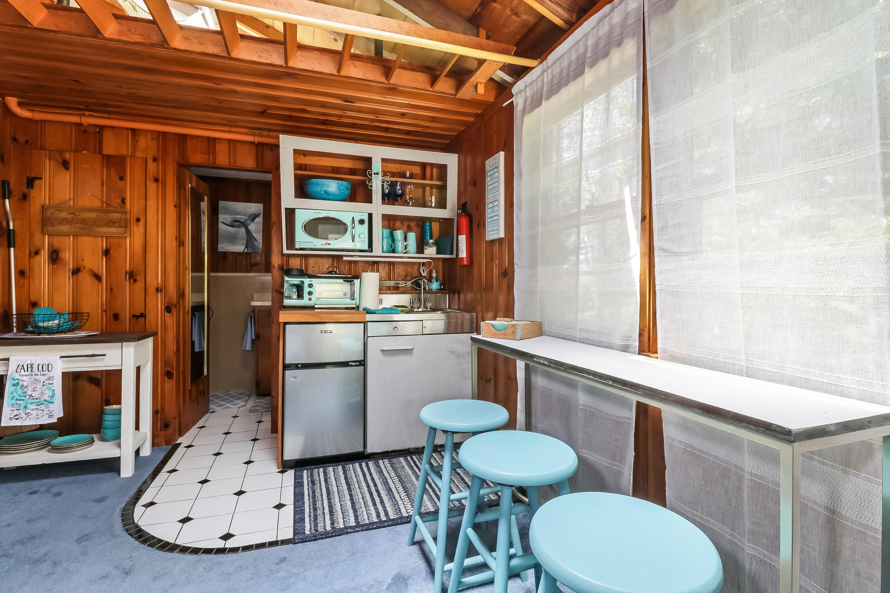 82 Shore Road, Unit 7 Truro, MA 02666 - Photo 6 of 13 a kitchen with a table chairs a stove and a fireplace