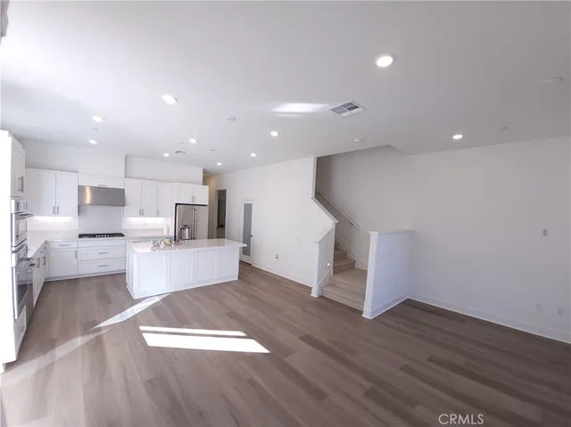 a view of kitchen and hall with wooden floor