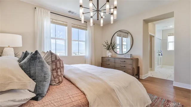 a bedroom with a bed mirror and a window