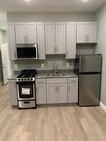 a kitchen with granite countertop white cabinets and stainless steel appliances