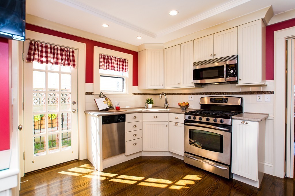 23 Virginia Road Waltham, MA 02453 - Photo 4 of 18 a kitchen with stainless steel appliances granite countertop a stove a sink and a microwave